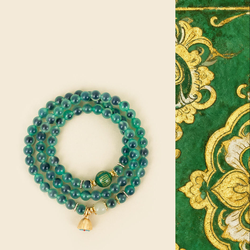 Full view of 108 green agate prayer beads with gilded lotus seed pod guru bead and good luck bell charm