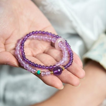 Hand holding a double wrap Amethyst bracelet featuring a translucent Agate Donut charm and turquoise accent