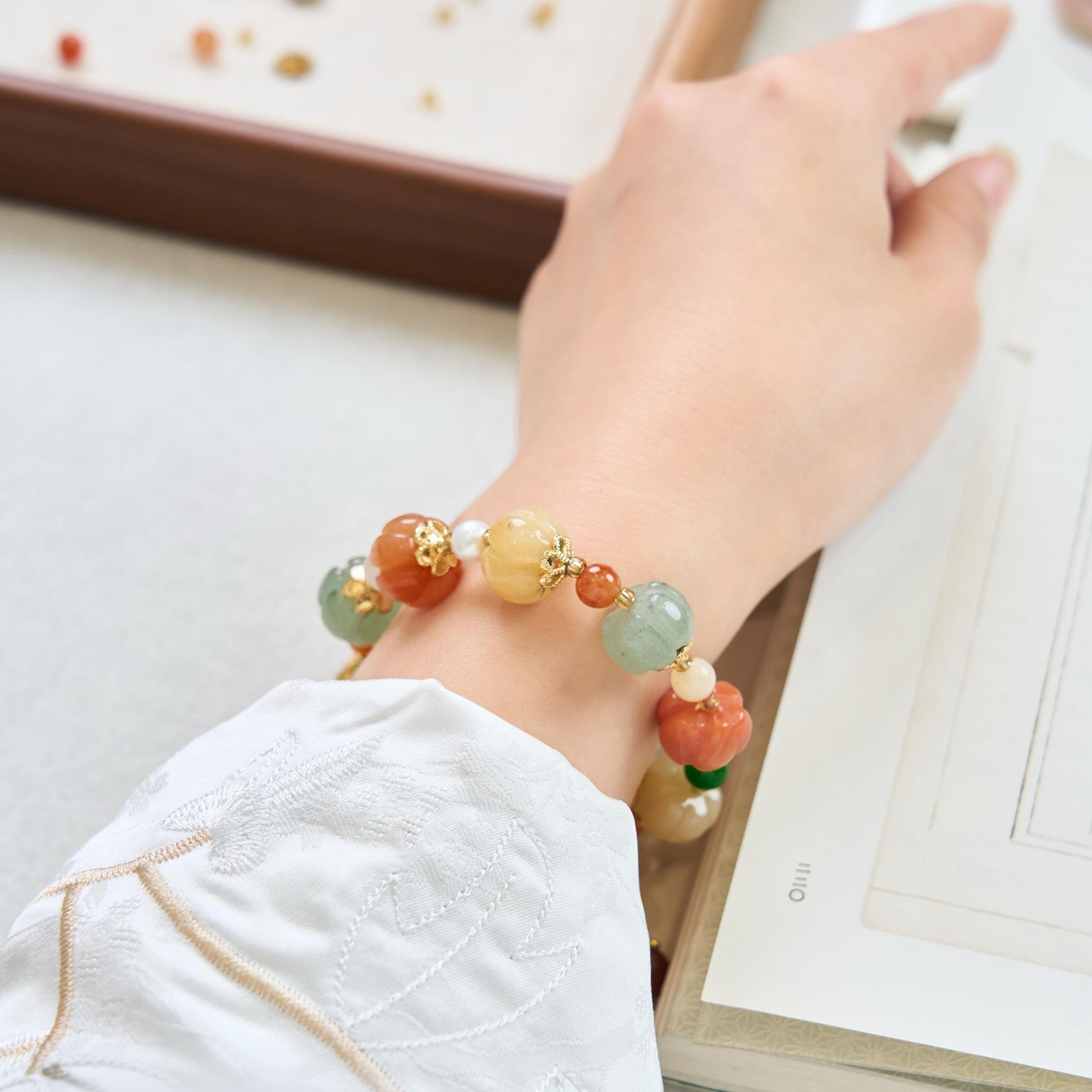 Elegant wrist shot of multi-colored Golden Silk Jade bracelet, a perfect spiritual jewelry gift for abundance