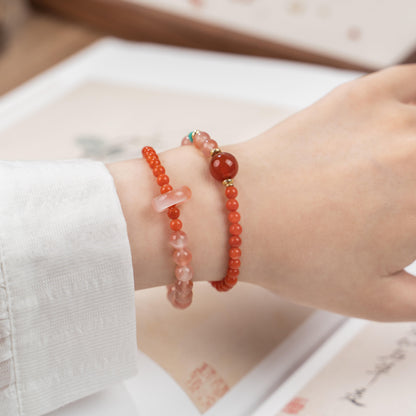 Woman wearing dainty red agate bracelet on wrist, highlighting the vibrant red beads for Root Chakra healing