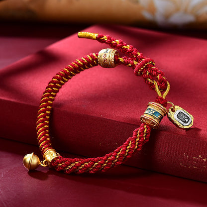 Red and gold braided corn knot bracelet with mantra barrel beads and dangling bell charm