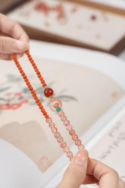Hands holding genuine Southern Red Agate bracelet showing the contrast between solid red and ice-translucent beads